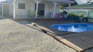 Ett takförsett utomhusområde med en pool, sittplatser och en liten bardisk.