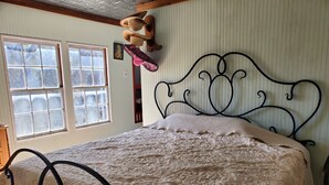 Ein Schlafzimmer mit Bett, Fenster und Deckenventilator.