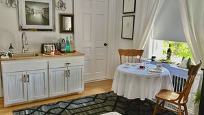 Une cuisine équipée d’un évier, d’un grille-pain et d’un coin repas avec une table mise pour deux personnes.