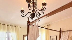 A bedroom with a canopy bed, wooden flooring, a chandelier, and a view of the outdoors. - Quinta Martin, spacious villa with views of Funchal and the Atlantic Ocean  (Funchal)