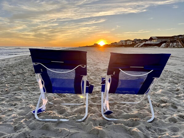 Rannalla, aurinkotuoleja, rantapyyhkeitä