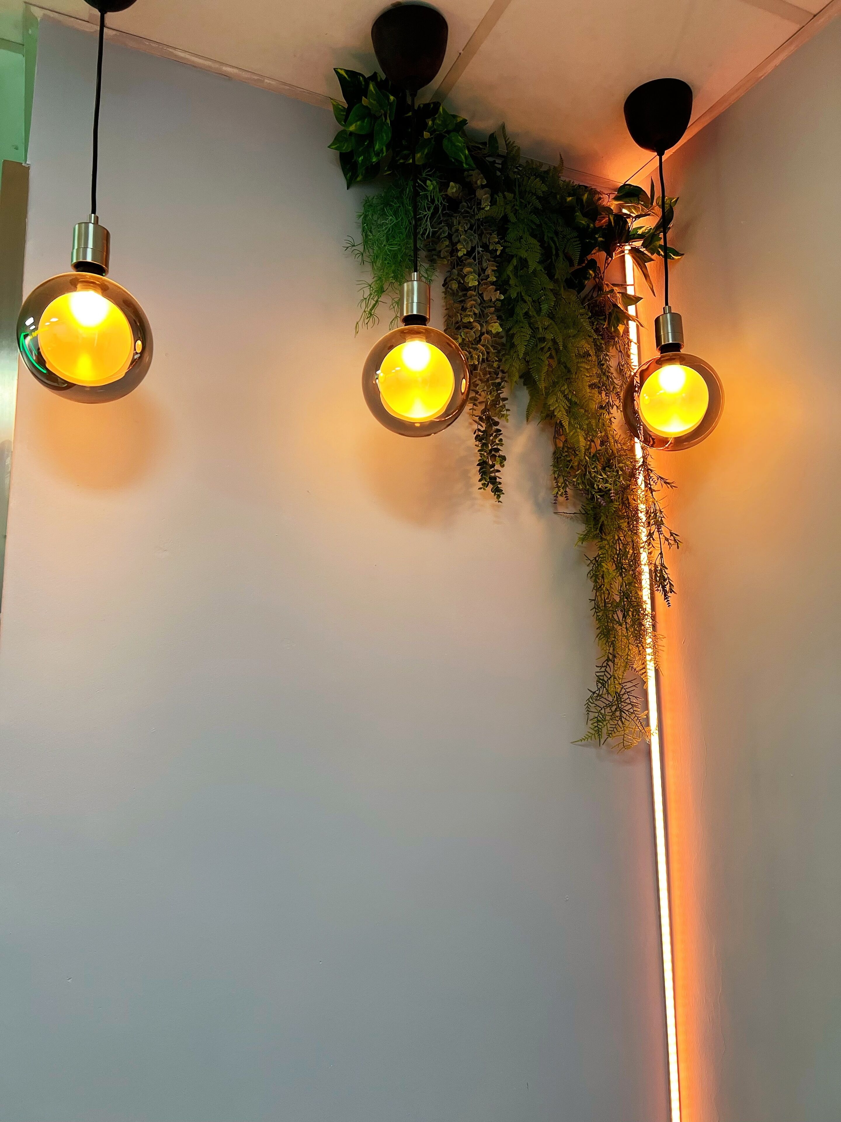 Three pendant lights with yellow bulbs hanging from the ceiling.