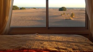 Una habitación con un ventanal amplio que da a un paisaje desértico.