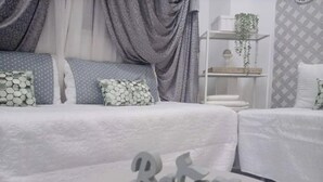 Une chambre à coucher bien rangée, avec un lit, des oreillers et une table de chevet agrémentée d’un objet décoratif.