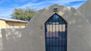 A gated entrance with a blue door and a letter 'C' on the wall. - UofA Tiny House + Fire Pit (Tucson)