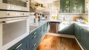 A kitchen with green cabinets, a stainless steel dishwasher, and a wooden floor. - Beautiful home in Gnesta with WiFi (Gnesta)