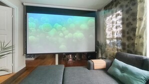 A living room with a large flat-screen TV mounted on the wall, a sofa, a coffee table, and a decorative plant. - Beautiful home in Gnesta with WiFi (Gnesta)