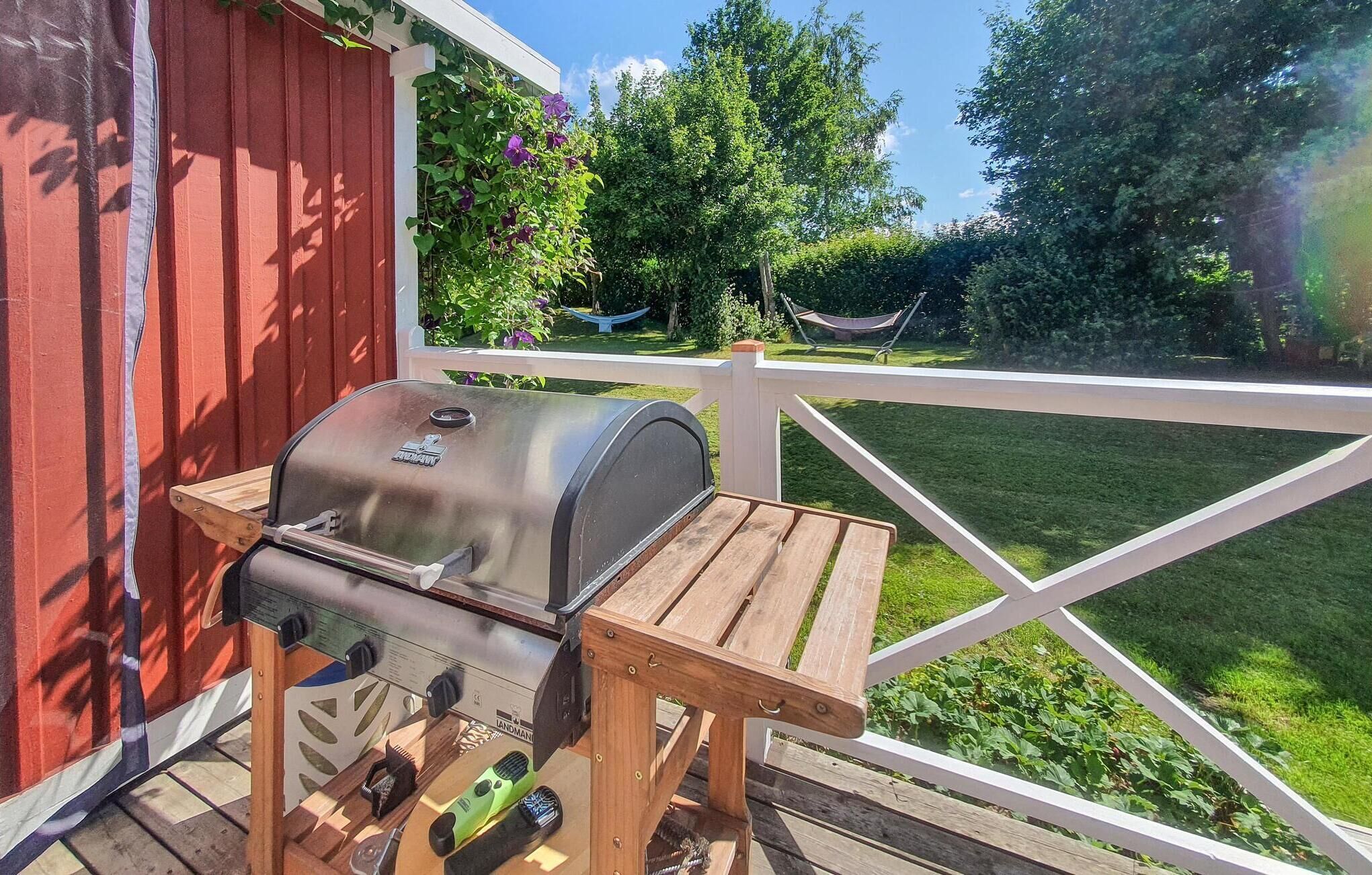 Ein Grill auf einem Holztisch, im Hintergrund eine weiße Brüstung.