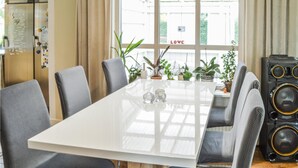 A modern dining area with a white table, grey upholstered chairs, and potted plants. - Beautiful home in Gnesta with WiFi (Gnesta)