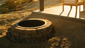 A patio with a fire pit, outdoor seating, and a view of a desert landscape. - Joshua Tree Monochrome - 5 mins from National Park (Joshua Tree)