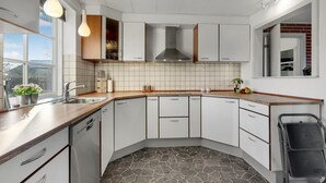 Eine moderne Küche mit weißen Schränken, einer Stein-Spritzschutzleiste und einem Geschirrspüler.