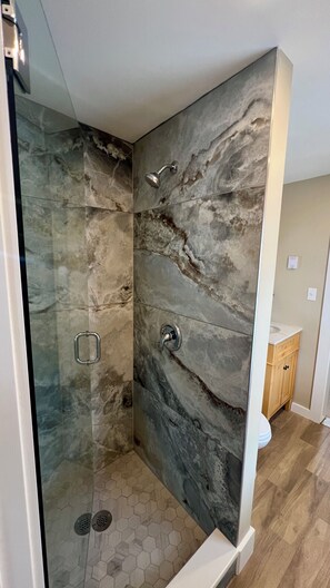 Bañera con ducha, toallas, jabón, shampoo