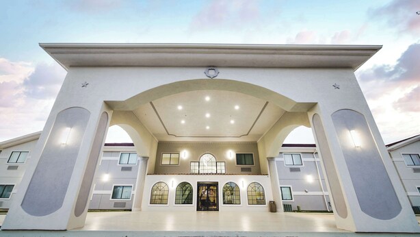 A building with a large entrance, arched windows, and a central door. - SureStay Studio by Best Western Conroe Downtown (Conroe)