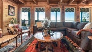 A cozy wooden interior with a sofa, bench, and round coffee table.