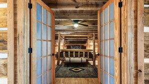 A wooden interior with a bench and a ceiling fan.