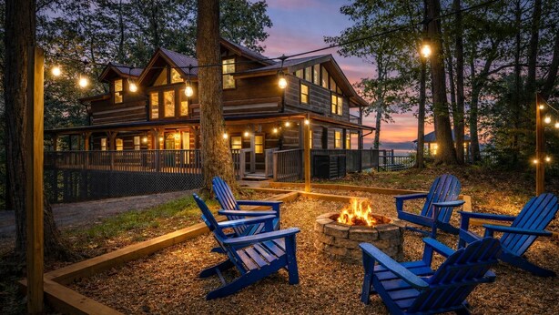 A cabin with a fire pit and Adirondack chairs in the yard.