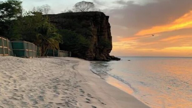 A beach with footprints leading to the water, a cliff, and a sunset. - Elegantly appointed 3 bed/rm 2 bath-unparalleled location to the beach access (Saint George)