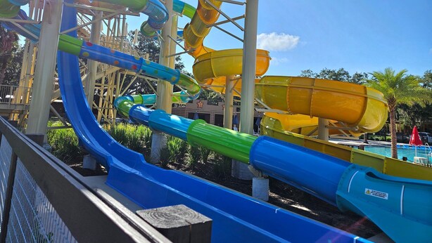 Un parc aquatique doté de nombreuses toboggans de couleurs variées : bleu, vert et jaune.