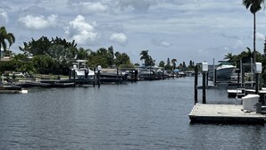 A marina with boats docked, palm trees, and a clear sky. - Beautifully remodeled in 2025. Gulf access. (New Port Richey)