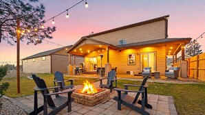 A house with a patio area featuring outdoor seating and a fire pit.