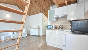A modern kitchen with white cabinets, a wooden ceiling, and a herringbone floor pattern. - Lovely home in Mouans-Sartoux with swimming pool (Mouans-Sartoux)