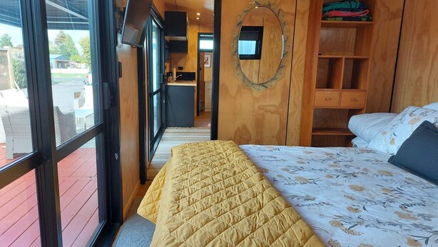 Ein Schlafzimmer mit einem Bett, einem Holzschrank und einem großen Fenster.
