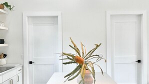 A modern kitchen with a white countertop, a black pendant light, and a decorative plant. - Lux Modern Barnhouse Cabin 1 minute from Hunter Mountain (Hunter)