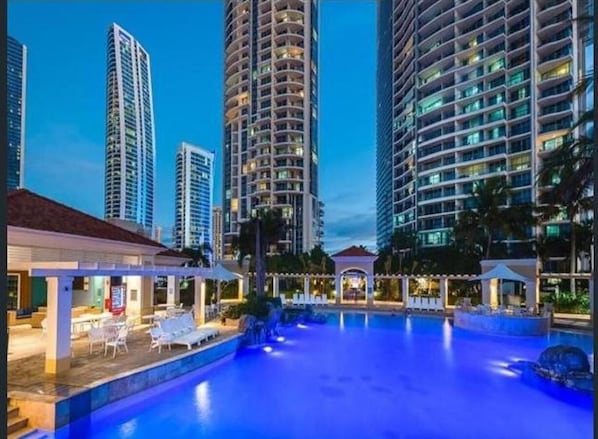 Relax by the pool surrounded by a covered patio with seating.