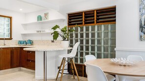 Enjoy cooking in this well-equipped kitchen with a central island, wooden cabinets, and a countertop with a unique pattern.
