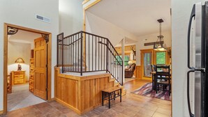 A spacious kitchen with a modern refrigerator, wooden flooring, and a dining area with a table and chairs. - Black Bear Lodge: Lovely 2BR+Loft Cedar Cabin Near Shows/Eateries/Ticket & Golf DEALS! (Branson)