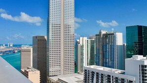 A high-rise building with a grid of windows, surrounded by other tall buildings and a clear blue sky. - Miami Downtown / Brickell (Miami)