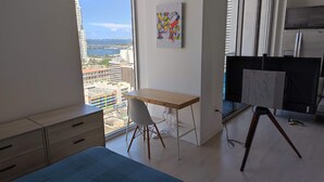 A modern bedroom with a large window, a wooden desk, a chair, and a bed. - Miami Downtown / Brickell (Miami)