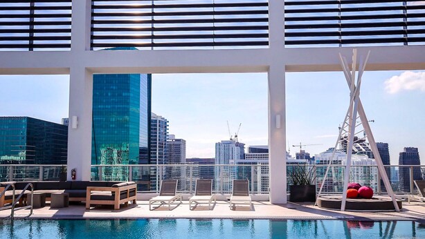 A rooftop pool area with lounge chairs, a seating area, and a view of the city skyline. - Miami Downtown / Brickell (Miami)