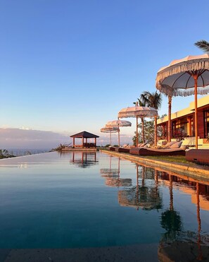A serene infinity pool with a clear view of the horizon, a gazebo, and lounge chairs with umbrellas. -  Uluwatu Sunset Hills (Pecatu)