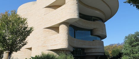A modern building with a unique curved architecture, featuring multiple levels and large windows.