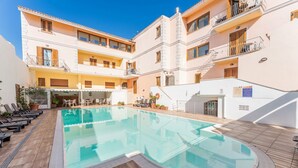 A pool area with a clear pool, wooden deck, and lounge chairs. - (30/45 sq m): living room with kitchenette, double sofa bed and a single folding bed, double bedroom, bathroom and balcony.<br>Features: <br>tv, <br>ironing board and iron (on request) <br>kitchenette with induction hub, <br>oven, <br>kettle, <br>microwa (Santa Teresa di Gallura)