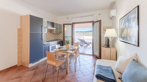 A compact living space with a kitchenette, dining area, and a balcony with a view. - (30/45 sq m): living room with kitchenette, double sofa bed and a single folding bed, double bedroom, bathroom and balcony.<br>Features: <br>tv, <br>ironing board and iron (on request) <br>kitchenette with induction hub, <br>oven, <br>kettle, <br>microwa (Santa Teresa di Gallura)
