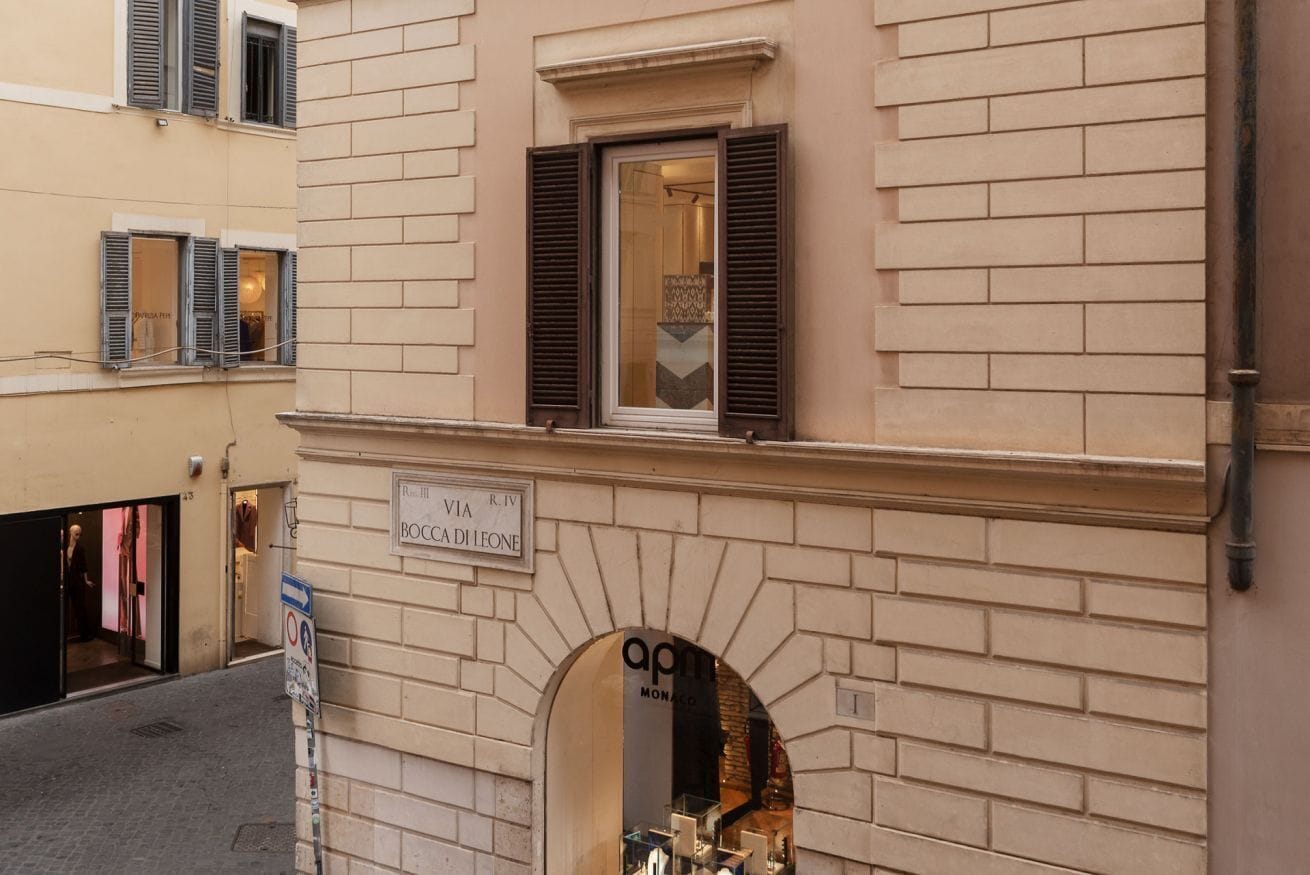 A building facade with a sign indicating 'Via Riva' and 'BOCA DI LEONE'.