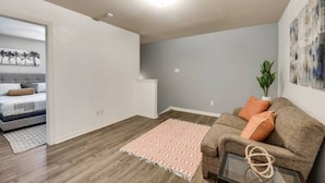 A modern living room with a sofa, a coffee table, and a patterned rug. - Spacious Farmhouse  Townhome*Walk to AT&T Stadium* (Arlington)
