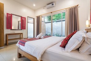 Relax in this inviting space with a large bed, nightstand, and window with beige curtains.