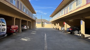 Un parking avec une pharmacie et un panneau indiquant les places de stationnement réservées aux personnes handicapées.