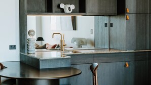 Una cocina moderna con armarios oscuros, una mesa redonda de comedor y dos sillas.