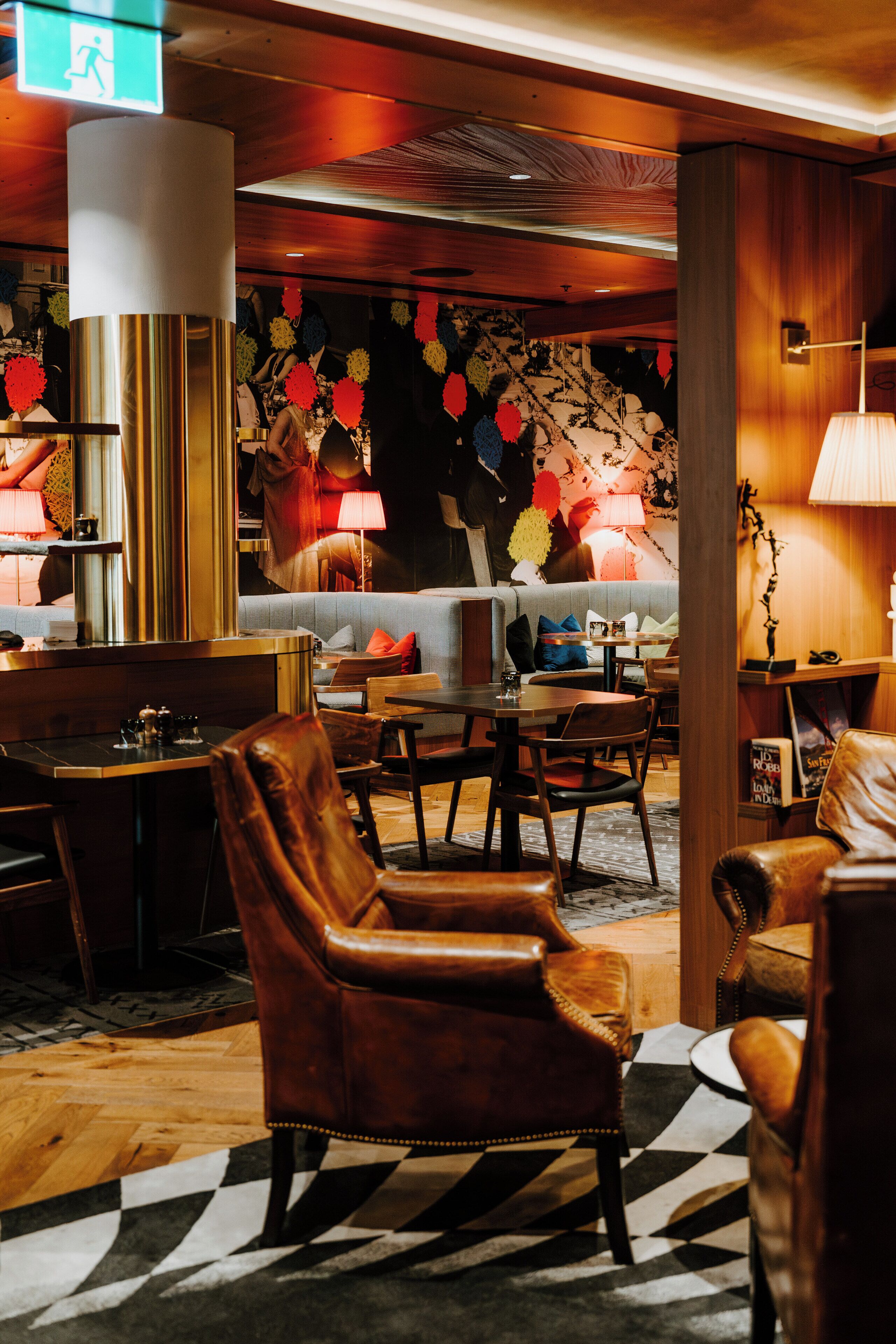 Een hotellobby met lederen stoelen, een bar en een wand met patroon.