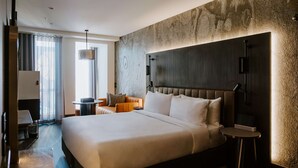 A modern hotel room with a large bed, a desk, and a chair. - The Motley Hotel Melbourne, Tapestry Collection by Hilton (Richmond)