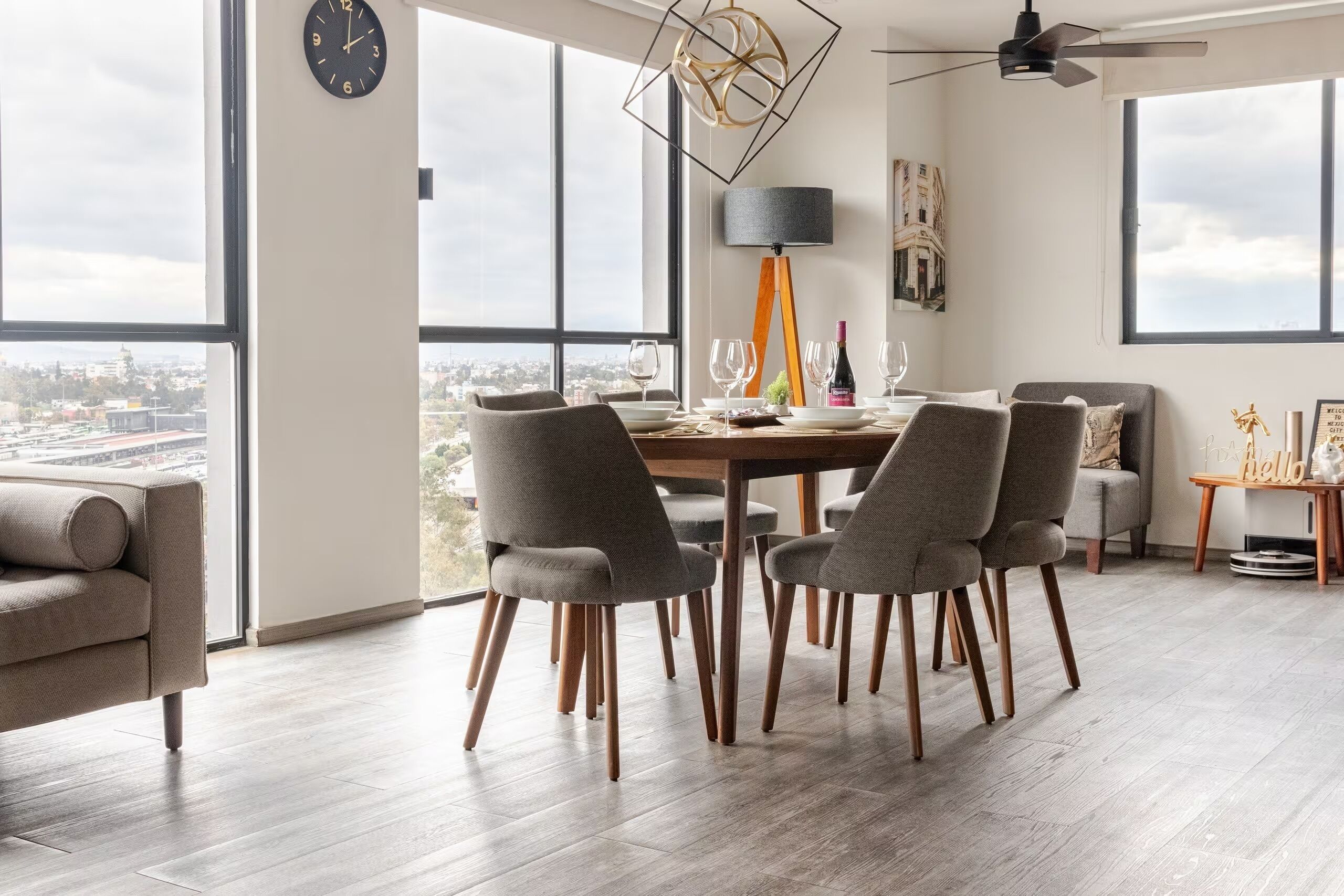 A modern dining area with a table set for four, large windows, and a city view.