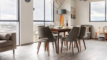 A modern dining area with a table set for four, large windows, and a city view.