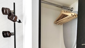 Ein Zimmer mit einer schwarzen Stehlampe, einem Holzsessel und einem hängenden Holzregal.
