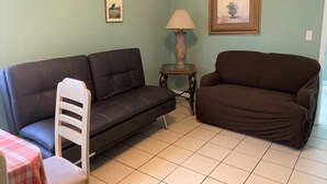 A living room with two sofas, a small table, and a lamp. - Downtown Sarasota Florida Vacation Rental 3BR/1.5BA House, Near Beaches, Unit 1 (Sarasota)