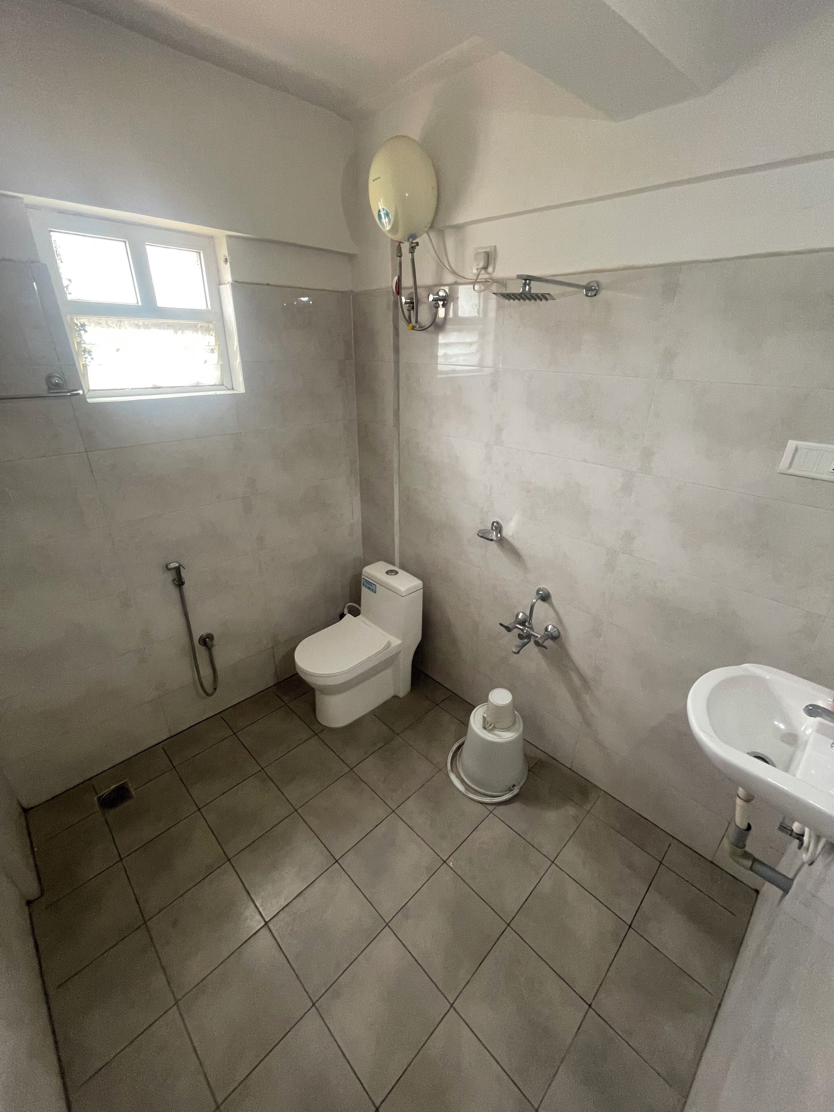 A bathroom with a toilet, bidet, shower, and sink.