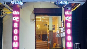 The entrance of BSIX Hotel with neon signs indicating "ROOMS" and "Lodge". - B SIX HOTEL AND LODGE (Bengaluru)